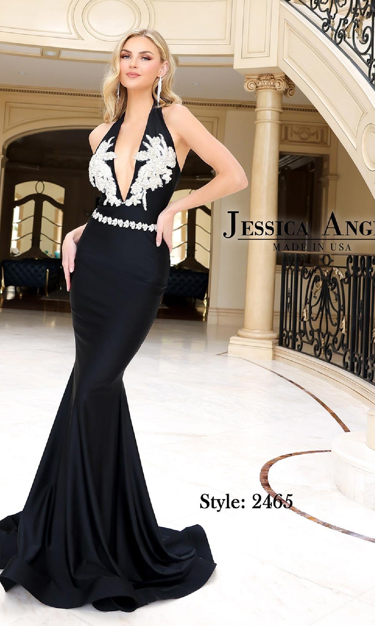 A woman poses indoors near a staircase wearing the Jessica Angel 2465 V-Neck Long Halter Prom Dress, a black fitted mermaid gown with white beaded appliques on the bodice. Text on image: “Style: 2465” and “Jessica Angel Made in USA.”.
